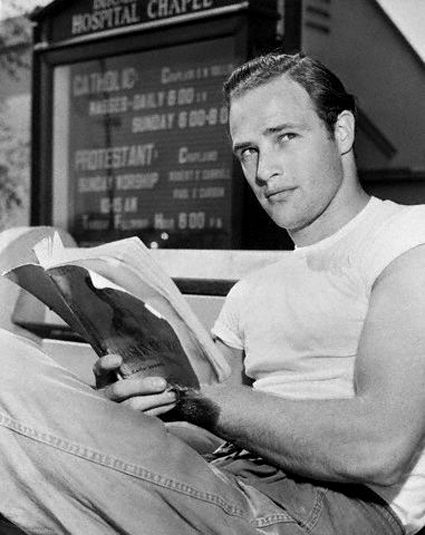 29 Nov 1949 --- Marlon Brando is pictured sitting down reading a book outside the Hospital Chapel --- Image by © Bettmann/CORBIS